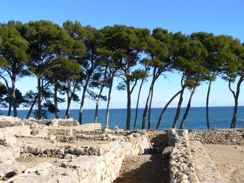 Walls of the ancient city with trees and blue sea and sky beyond