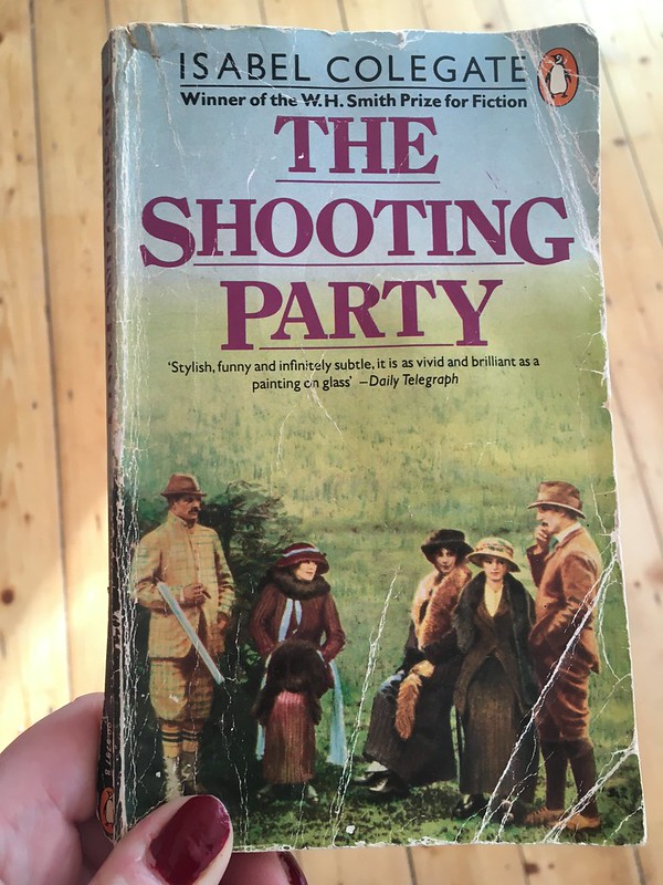 Cover of a battered paperback copy of 'The Shooting Party' by Isabel Colegate with a group of people in Edwardian dress with rifles on the cover.