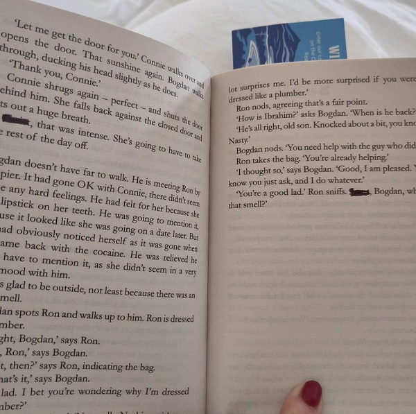 Two open pages of a printed book with two words scored out in black biro