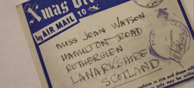 An old airmail envelope with a blue banner across the top that says 'Xmas Greetings by air mail to' and the address 'Miss Jean Watson, Hamilton Road, Rutherglen, Lanarkshire, Scotland.' Pic credit: Glasgow University Archives and Special Collections: ASC 013 A/61: Airmail Xmas Card (1942)